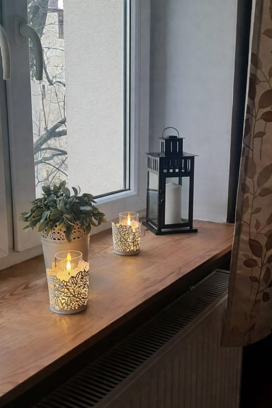 Windowsill with plant, candles and lantern